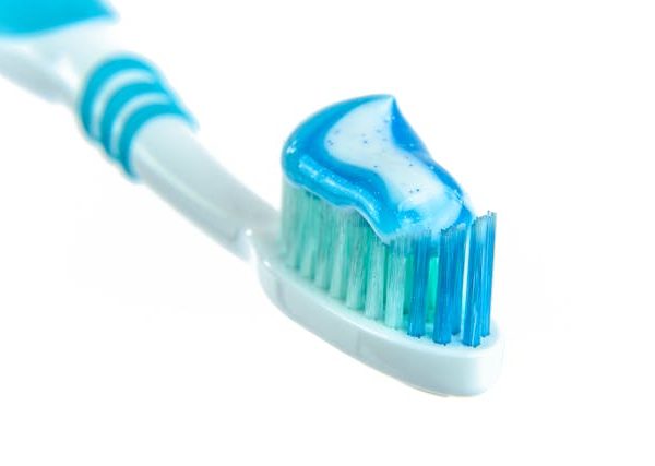 Blue and White Toothpaste on Toothbrush